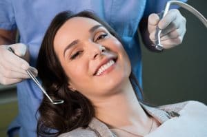 Smiling young woman receiving dental checkup