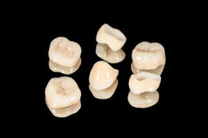 ceramic dental crowns and veneers. Isolate on black background close-up. Dental laboratory