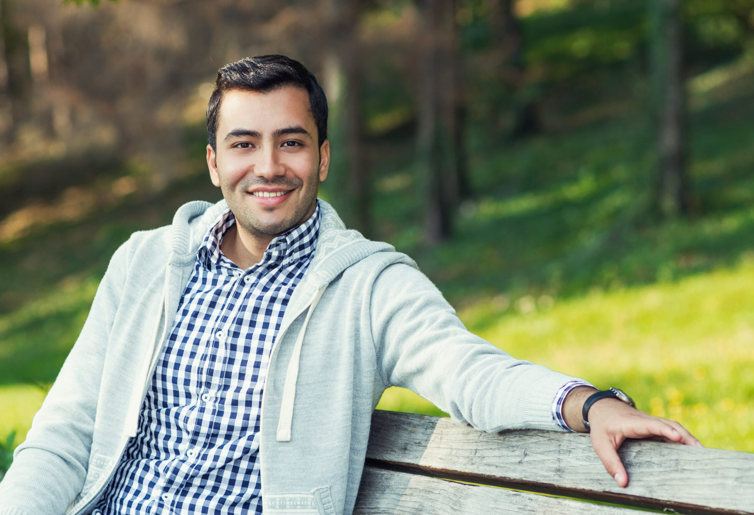Young man smiling on park bench